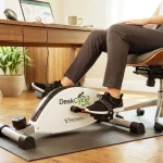 The DeskCycle white under-desk bike pedal exerciser actively used by a professional while working at their home office desk.