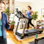 A middle-aged American woman happily exercises in a bright, fully equipped home gym, featuring a NordicTrack treadmill, a Schwinn recumbent bike, and a Concept2 rowing machine.