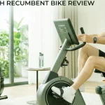 A cheerful Caucasian woman with short curly hair is happily using a modern MERACH recumbent exercise bike for a low-impact home workout to manage type 2 diabetes.